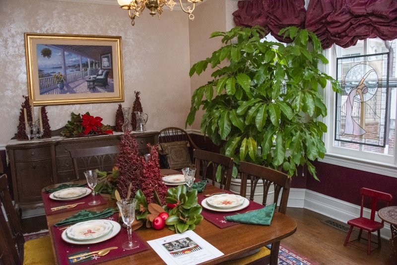 The holiday table is set at Beebe Frazer’s Second Street home, and the healthy Schefflera tree adds a touch of life to the room.